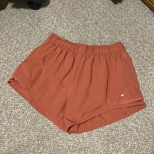 Large burnt orange LEG3ND shorts with adjustable drawstrings